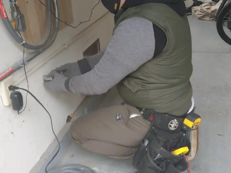 Electrician performing outlet wiring in a Rib Mountain garage